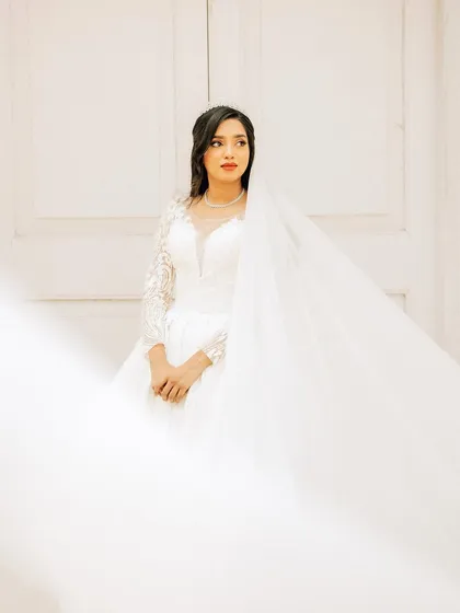A serene bridal portrait. I use soft, natural light to highlight the bride's elegance and the delicate details of her veil and gown, creating a timeless and ethereal image.
