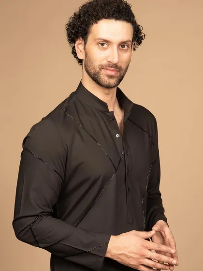 A closer look at the black kurta, focusing on the unique collar and the precise stitching details. It’s a minimalist piece that makes a powerful statement.