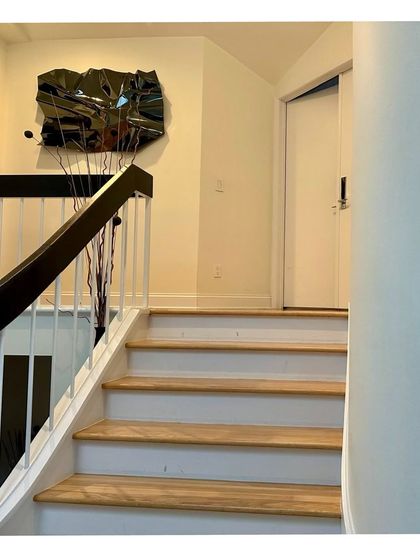 A black stainless steel sculpture from the Meteor series adds a touch of drama to a client's staircase landing.