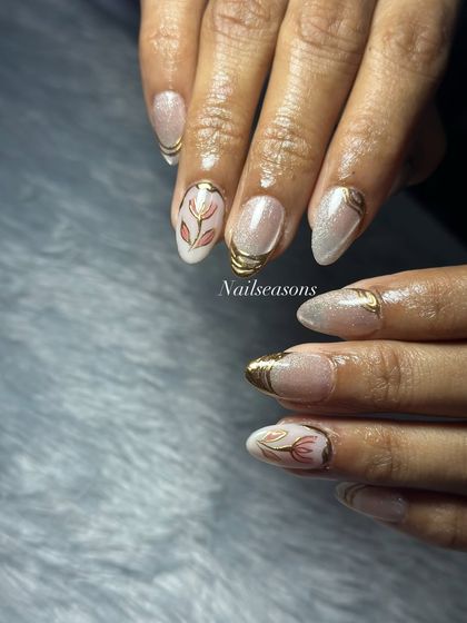 Golden glam with a touch of floral elegance. This design features a shimmery cat eye base with gold chrome tips and hand-painted floral accents.