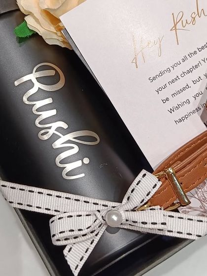 A close-up of the personalized coffee sipper and luggage tag from the farewell hamper.