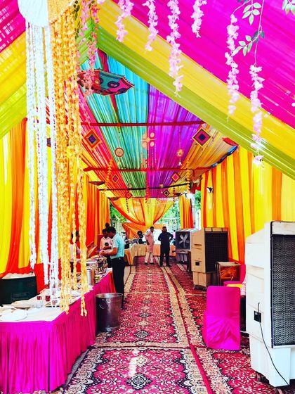 Another view inside the housewarming tent, showing the hanging floral decorations and the spacious arrangement for guests.