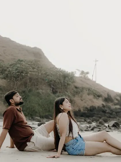 Leaning on each other, soaking in the sea breeze. This candid moment captures the couple in a state of complete relaxation and togetherness on their beach pre-wedding shoot.