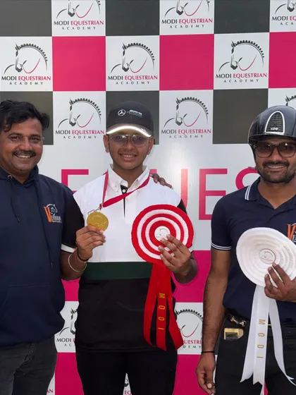 A student celebrates his gold medal win with his coaches. We foster a close-knit community where every success is shared.