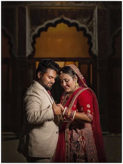 An intimate portrait of a couple, beautifully lit to create a warm and romantic mood. The traditional architecture in the background adds a touch of timeless elegance.