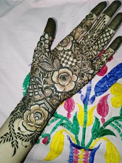 A beautiful floral design with a mix of roses and other flowers, combined with delicate jaal work on the fingers.