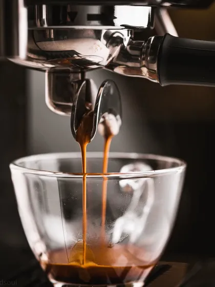 A dramatic shot of two streams of espresso pouring into a glass cup. The symmetry and rich color make this a very satisfying and high-impact photograph.