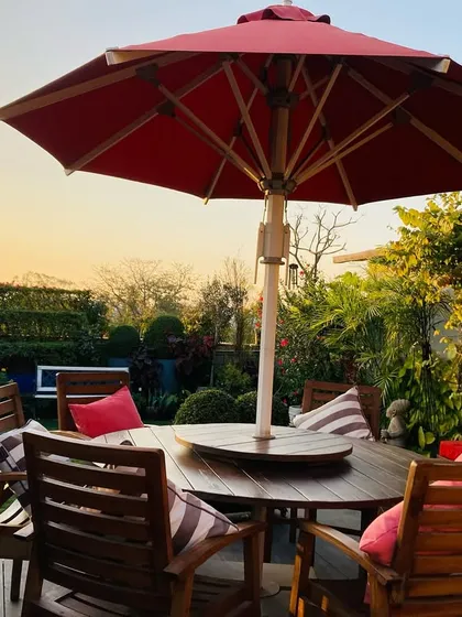 A terrace garden is a promise of a pleasant evening. This space, with its comfortable wooden deck and seating, becomes a front row seat to the sky's changing moods, offering a peaceful retreat to watch the sunset.