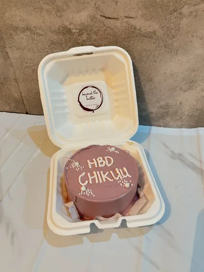 A lovely mauve-colored bento cake with "HBD Chikuu" written in white, showing a simple and elegant way to send birthday wishes.