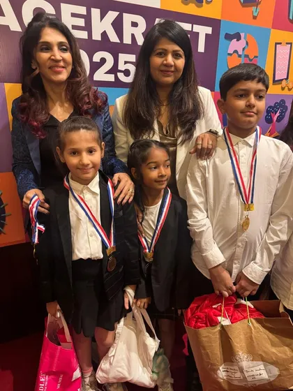 A proud teacher with her students after the show, all wearing their medals with big smiles.