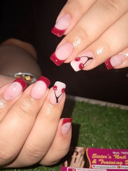A classic red French manicure on square nails. We added a cute hand-painted cherry design on the accent nail for a pop of fun.