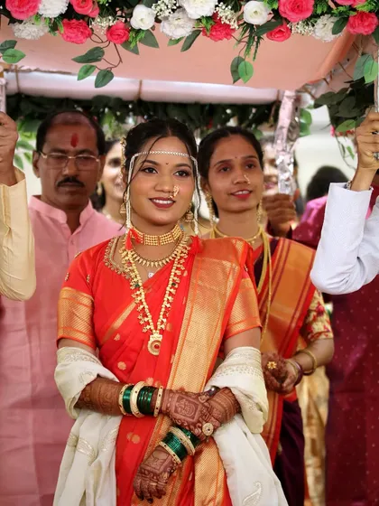 The bride's entrance under the phoolon ki chadar. All eyes are on her, and her radiant makeup ensures she looks her absolute best.