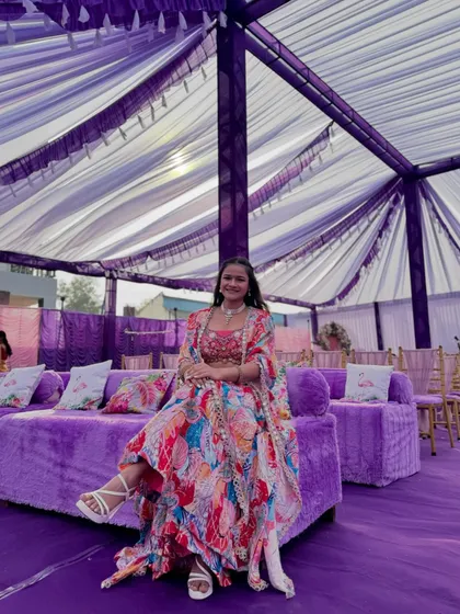 A full view of the seating area at the vibrant purple-themed Haldi carnival.