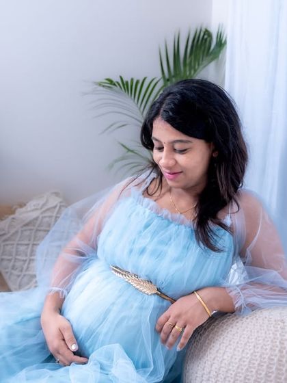 A dreamy lifestyle session in our studio. The mom-to-be is relaxing in a light blue gown, surrounded by soft, airy decor.