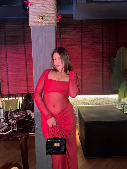A sheer red long-sleeved dress, a bold and festive choice for a Christmas party.