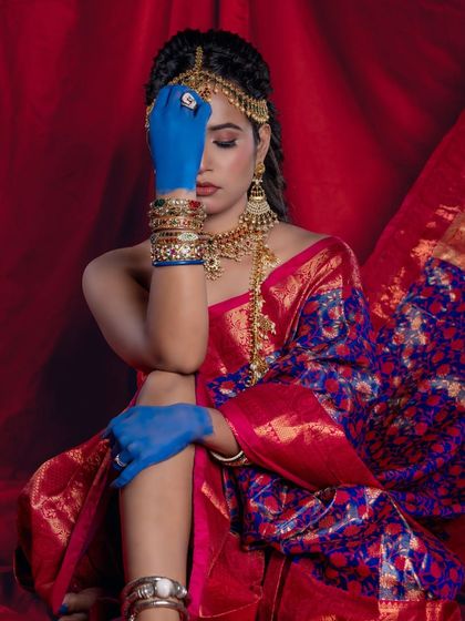 A contemplative pose that highlights the matha patti and the texture of the silk saree.