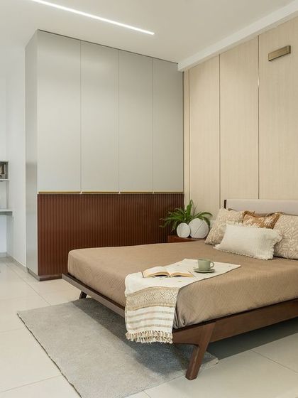 This bedroom in the mock-up unit features a calm, neutral palette with wood-paneled and fluted accent walls. A minimalist floating shelf serves as a sleek and functional study desk, maximizing space while maintaining a clean aesthetic.