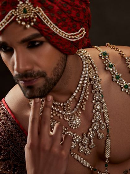 A powerful portrait showcasing a layered necklace look for men. This styling challenges traditional notions of masculinity, using classic hues and modern aesthetics to create something truly unique.