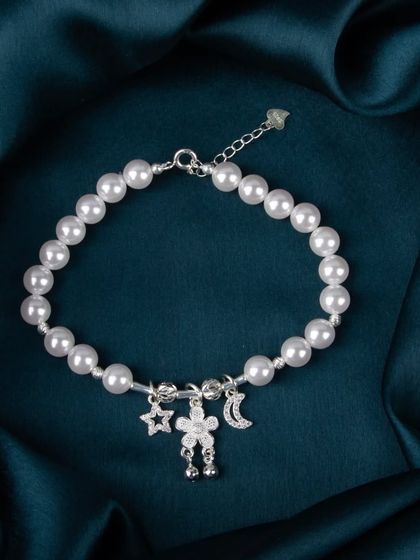 A charming silver and pearl bracelet with star, moon, and flower-person charms.