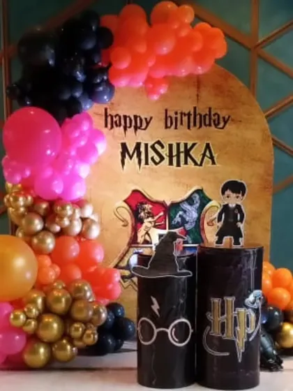 A personalized Harry Potter backdrop for Mishka's birthday. The design includes the Hogwarts crest, a sorting hat, and other iconic symbols from the wizarding world.