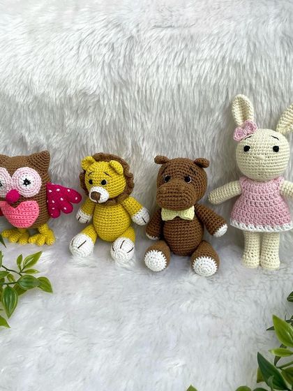 A collection of animal friends made as newborn photo props. This set includes a colorful owl, a lion, a hippo, and a bunny.