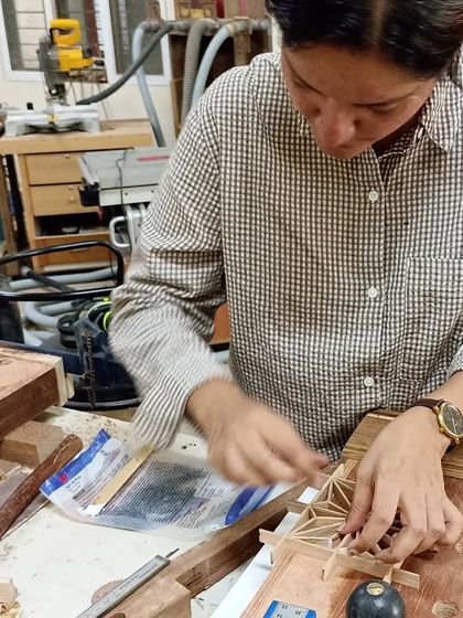 Anju, deep in concentration during a Kumiko workshop. She is using a small plane to perfect the fit of the intricate pieces, a testament to the precision required in this art form.