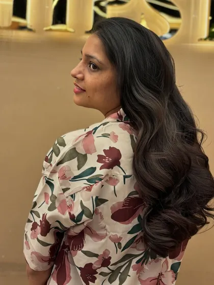 A side view of a client's new haircut. The long layers and soft waves create a look that is both classic and modern.