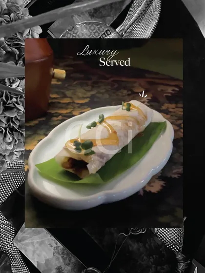 Luxury served on a leaf. This delicate roll, drizzled with a savory sauce, is an example of our elegant canapé service. Each bite is crafted to deliver a sophisticated and memorable flavor experience.