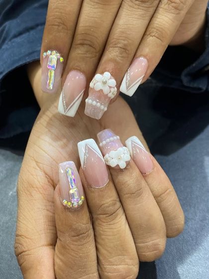 An incredibly detailed set featuring 3D pearl flowers, iridescent rhinestones, and white line work on coffin nails.