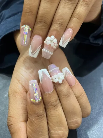 An incredibly detailed set featuring 3D pearl flowers, iridescent rhinestones, and white line work on coffin nails.