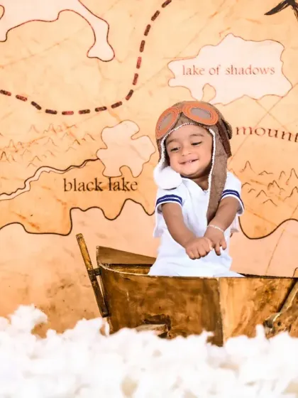 A little explorer in a pilot's hat, navigating through clouds with a treasure map in the background.