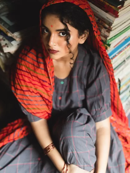 Another angle of the character-driven editorial, showing the natural-looking makeup and softly styled curls under a headscarf. The focus is on creating a believable and evocative look.