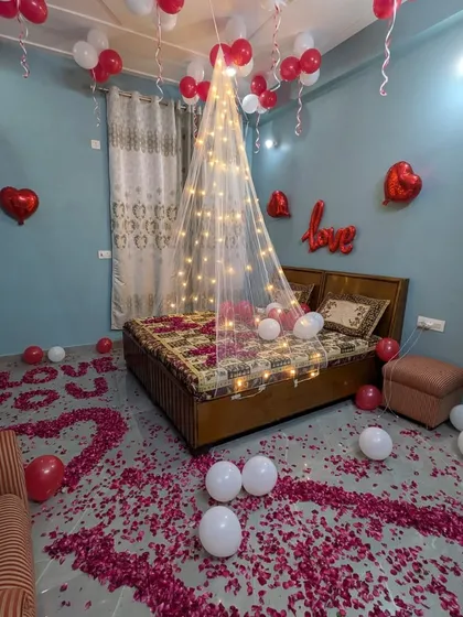 I transform ordinary bedrooms into romantic retreats. This setup features a sheer bed canopy with fairy lights, a floor scattered with rose petals, and balloon arrangements to create a cozy and intimate atmosphere.