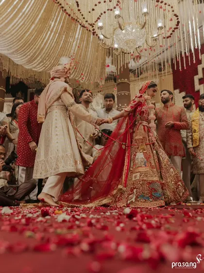 The seven sacred steps, or Saptapadi, are the foundation of the marriage. I create a path of scattered rose petals for this ritual, symbolizing a beautiful and fragrant journey ahead, all under a canopy of cascading floral strings.