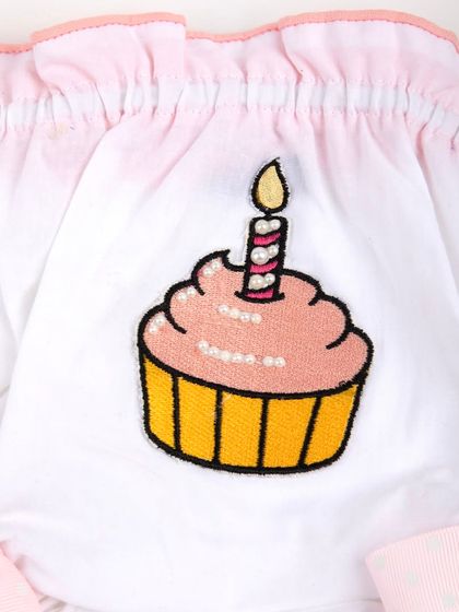 A macro shot of the sequined cupcake and candle embroidery.