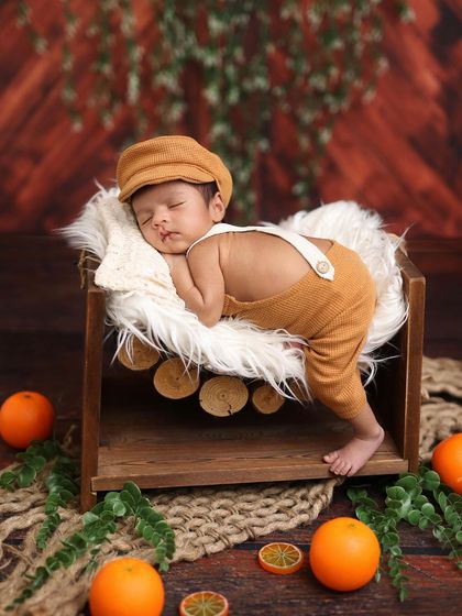 This little gentleman is ready for his nap in the woods, wearing a cute cap to match his rustic outfit.