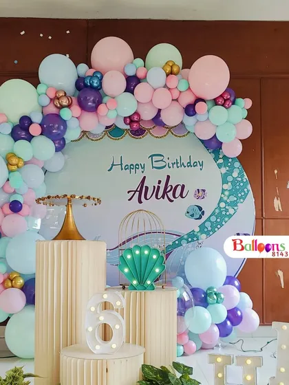 A closer look at the central backdrop for Avika's mermaid party. The pastel balloon arch is accented with gold balloons for a touch of sparkle.
