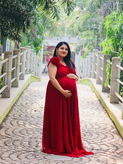 This classic red maternity gown with cap sleeves is a timeless choice. It provides a beautiful silhouette and a pop of color for outdoor photoshoots on pathways and bridges.