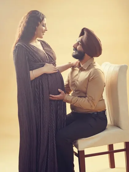 A tender moment during a studio maternity session. The simple elegance of the pleated cape gown allows the couple's connection to be the main focus of the photograph.
