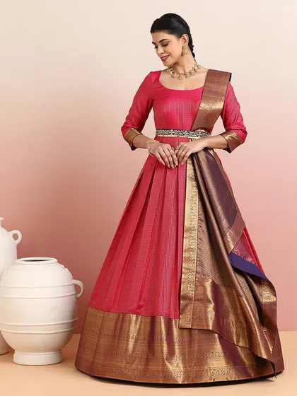 A beautiful pink and deep blue half-saree lehenga with a wide gold zari border. The three-quarter sleeves and elegant drape make it a graceful and timeless choice.