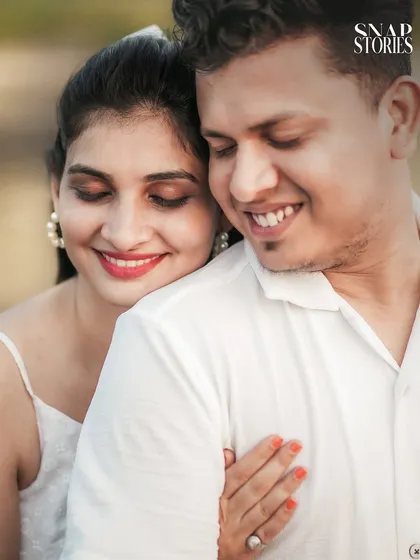 An intimate close-up portrait of a couple in a tender embrace, capturing their peaceful and happy expressions during their beach photoshoot.