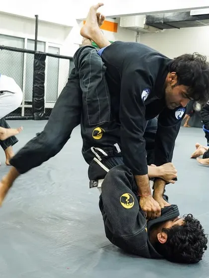 A dynamic guard pass in action during a Gi jiu-jitsu class. This kind of movement, combining agility and technique, is what makes BJJ so effective.