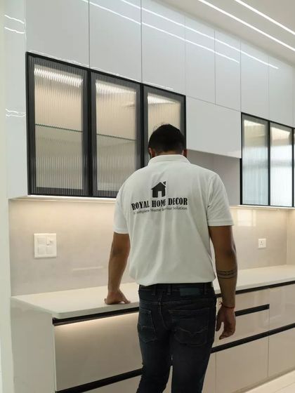 A look at the completed kitchen from the living area, showcasing the fluted glass cabinets and integrated lighting.