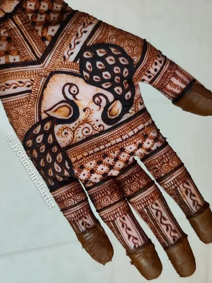 A close-up of the palm design featuring two peacocks. Even within a fuller design, I use spacing to ensure the motifs are clear and beautiful.