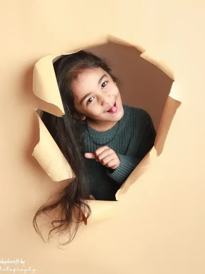 A playful wink and a cheeky expression make this shot from the paper-tear series a standout.