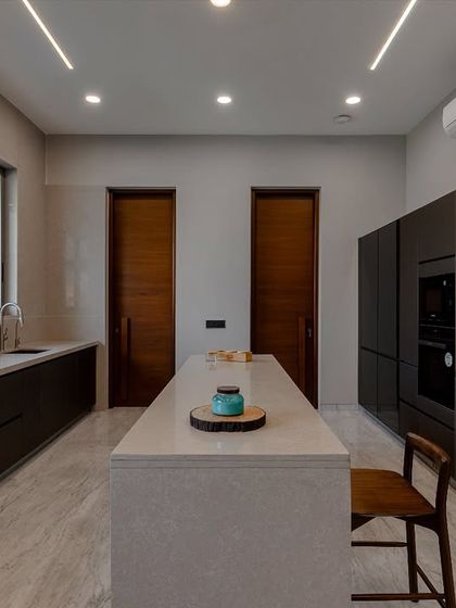 The long, clean lines of this kitchen are emphasized by the handleless cabinetry and linear lighting. The layout is designed to be spacious and uncluttered, ideal for a busy family home.