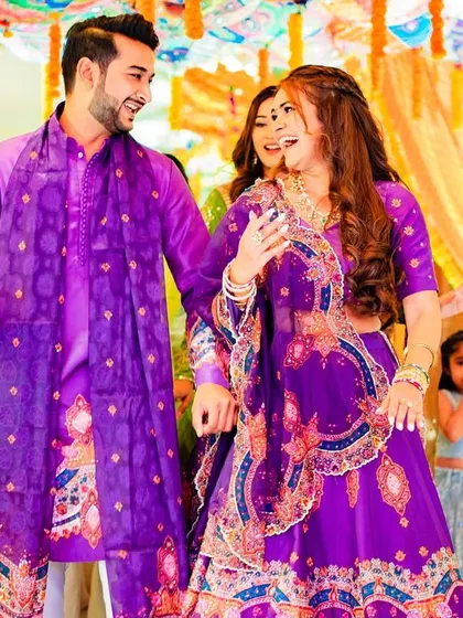 A fun, candid shot from a sangeet, with the bride's wavy hair flowing as she dances.