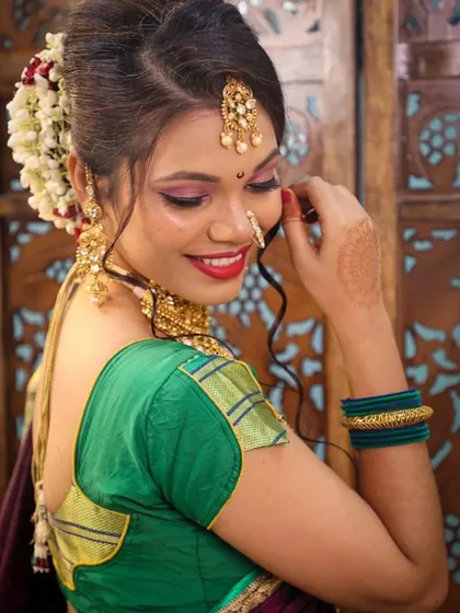 A beautiful smile from one of our Maharashtrian brides. This student's work showcases a perfect blend of traditional elements like the nath and modern makeup techniques for a fresh, glowing finish.