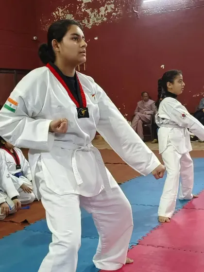 A senior student demonstrates a strong, focused stance during Taekwondo practice. Her posture and concentration show the discipline and mental stillness we cultivate in our classes.