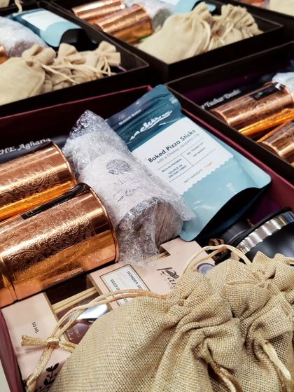 A closer look at the contents of my corporate hampers. This one includes premium copper mugs, a personalized flask, healthy snacks, and other goodies packed in jute pouches. Every item is chosen for its quality and utility.